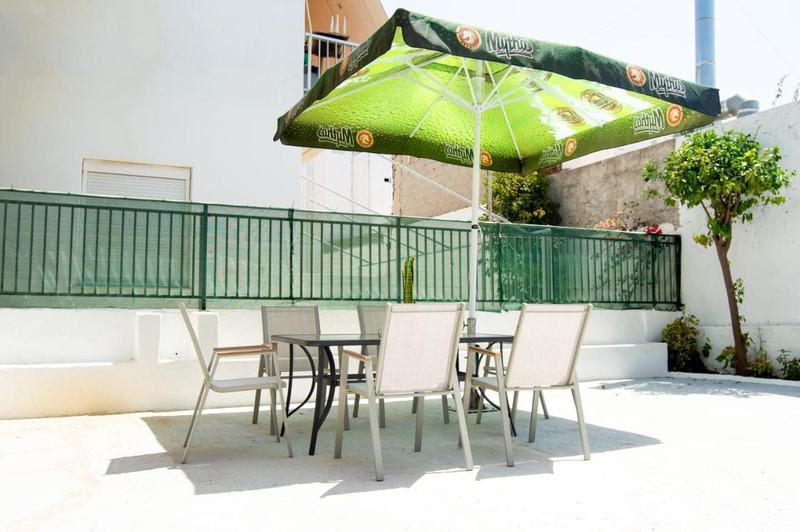 Outdoor dining table for four under a parasol in the courtyard