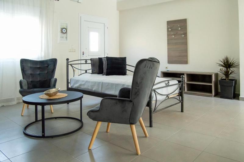 Bright living room with velvet armchairs, daybed and round coffee table