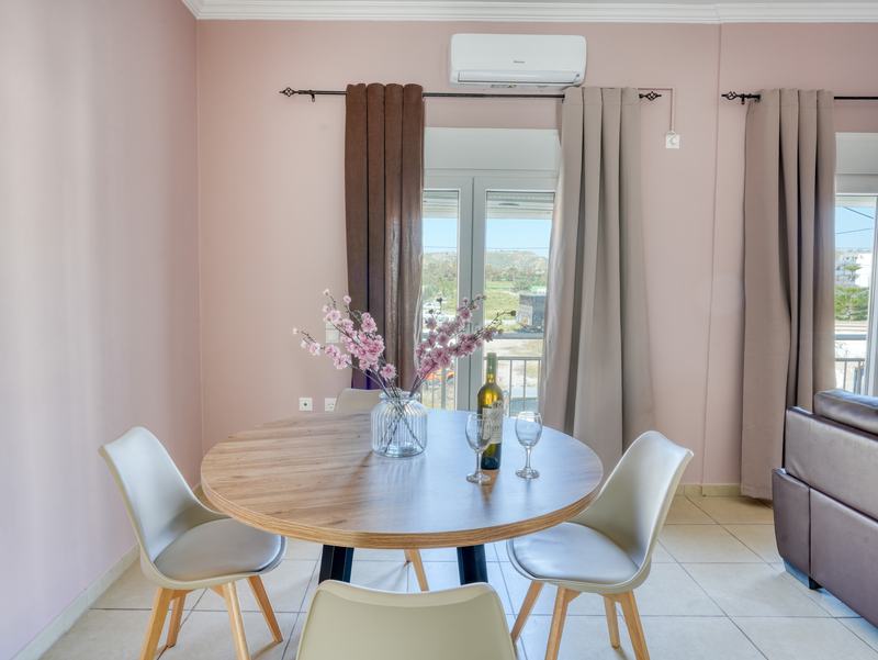 Round dining table with blossom and wine by the balcony doors