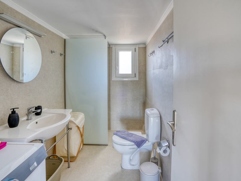 Bathroom with walk-in shower and round mirror
